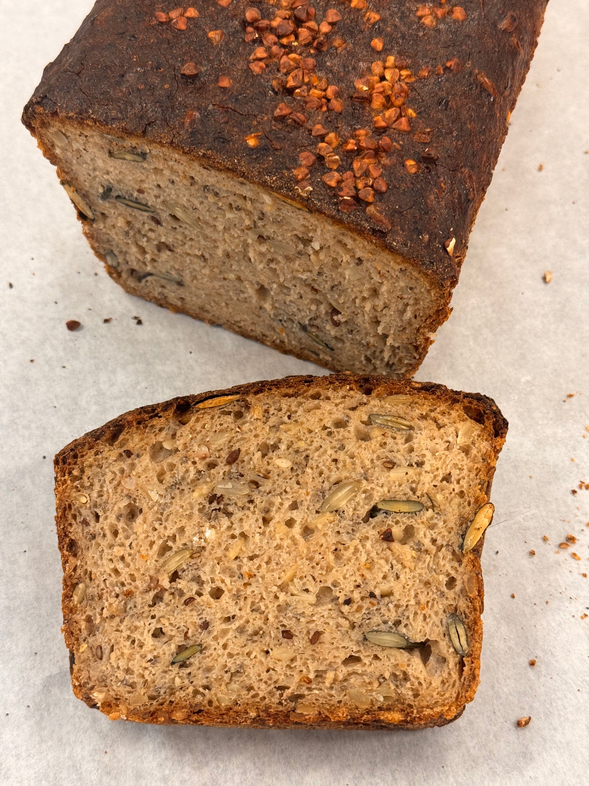 Two slices of whole grain bread on a light gray surface